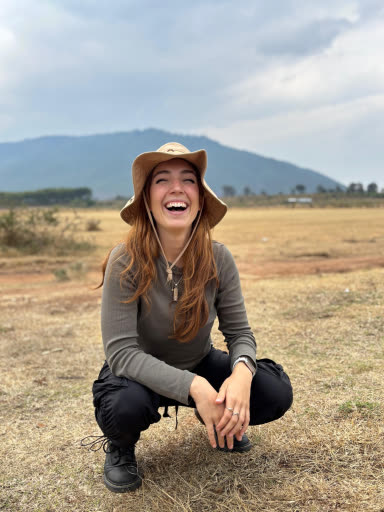 StudyTme sitting in a field in Kenya
